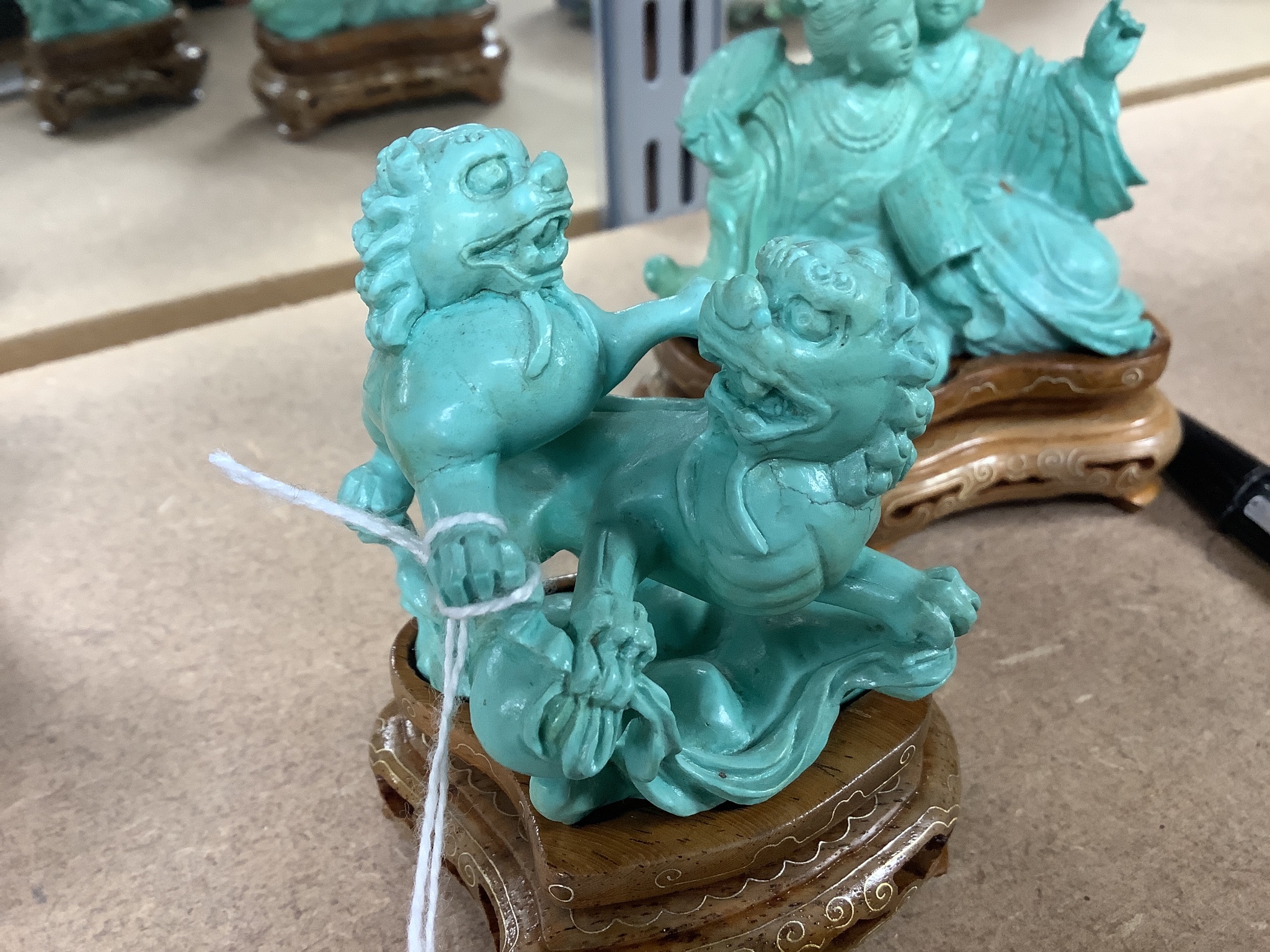 Two Chinese turquoise matrix groups of lion-dogs and of two kneeling ladies, mid 20th century, wood stands, height 9cm